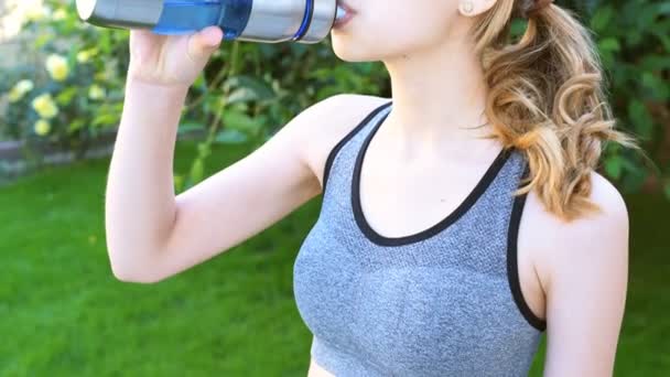 Молодая девушка пьет воду после тренировки . — стоковое видео