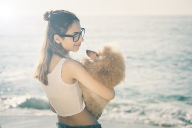 Genç kız denizde bir köpekle dinleniyor.