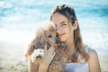 Genç kız denizde bir köpekle dinleniyor.