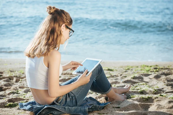Flickan med en digital tablett vid havet. — Stockfoto