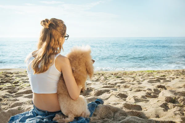 Молодая девушка отдыхает с собакой на море . Лицензионные Стоковые Изображения