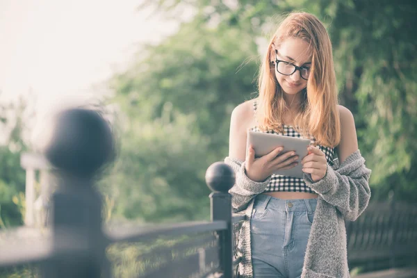 Flickan med en digital tablet utomhus. — Stockfoto