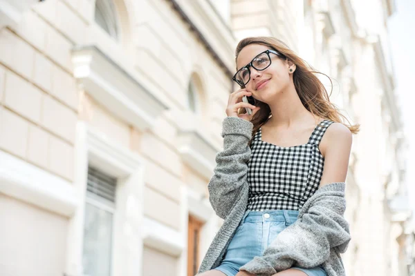 Jeune femme parlant au téléphone dans la rue . — Photo