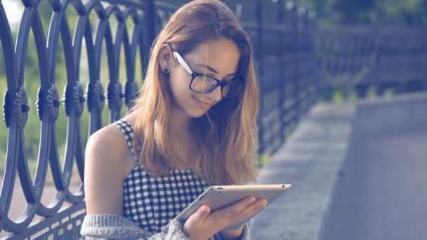 Menina usando um tablet digital ao ar livre . — Vídeo de Stock