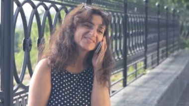 Sokakta telefonla konuşan genç bir kadın. . 