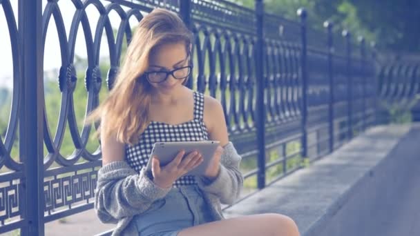 Flickan med en digital tablet utomhus. — Stockvideo