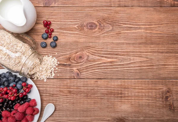 Smoothies aux flocons d'avoine, baies en pots de verre sur fond de bois . — Photo