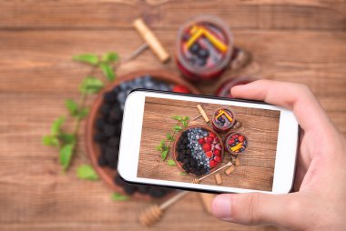 Sangria ile smartphone taze çilek ile eller fotoğrafta kırmızı şarap.