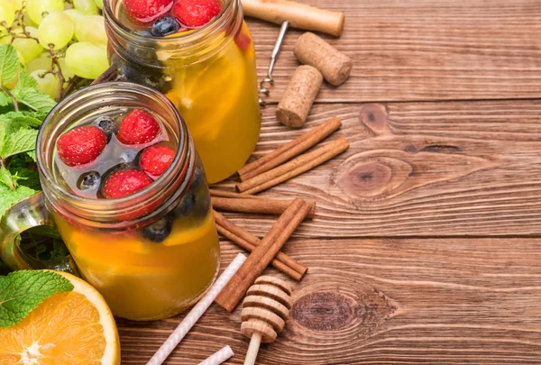 Sangria de vin blanc maison avec des baies fraîches sur une table en bois . — Photo