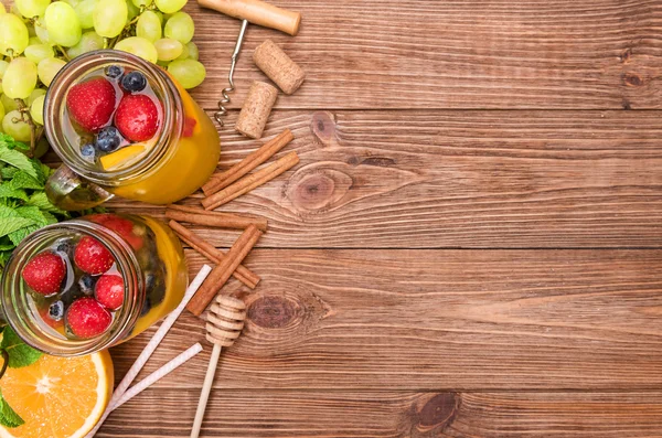 Hemgjord vit vin sangria med färska bär på ett träbord. — Stockfoto