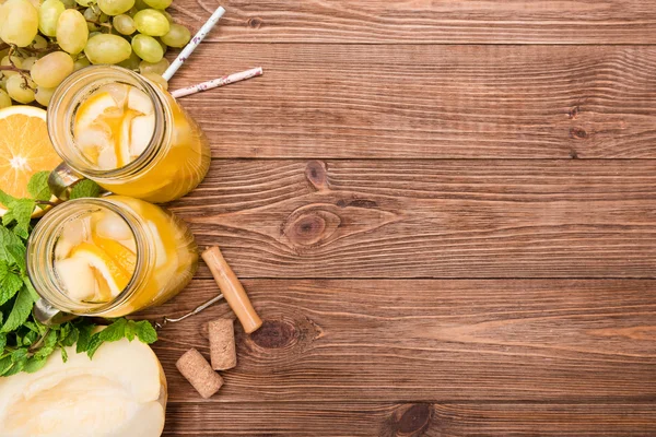 Sangria de vinho branco caseiro com melão e laranja em uma mesa de madeira . — Fotografia de Stock