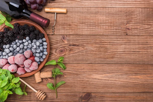 Sangria casera de vino tinto con bayas frescas sobre una mesa de madera . —  Fotos de Stock