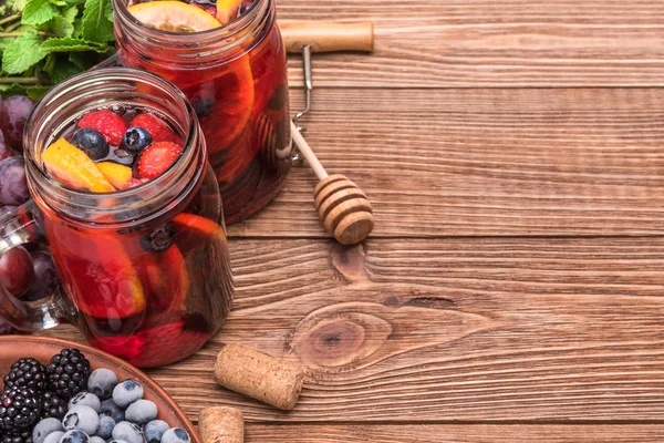 Sangria de vinho tinto caseiro com bagas frescas em uma mesa de madeira . — Fotografia de Stock