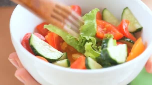 Chica joven comiendo una ensalada de verduras después de un entrenamiento  . — Vídeos de Stock