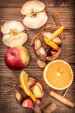Ev yapımı kırmızı şarap sangria ile elma ve portakal ahşap bir masa üzerinde.