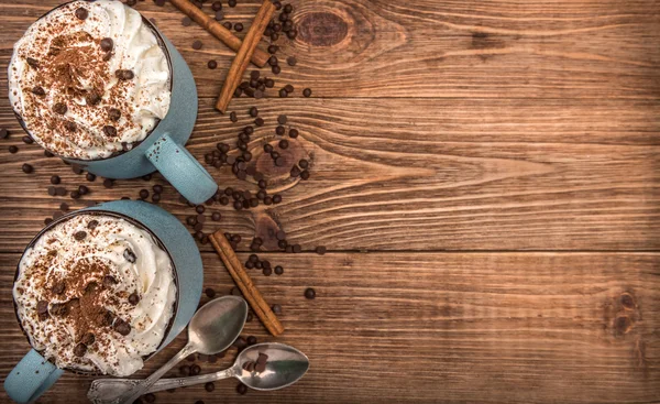 Varm choklad med vispgrädde i mugg på ett träbord. — Stockfoto