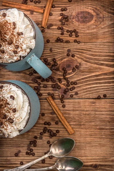Varm choklad med vispgrädde i mugg på ett träbord. — Stockfoto