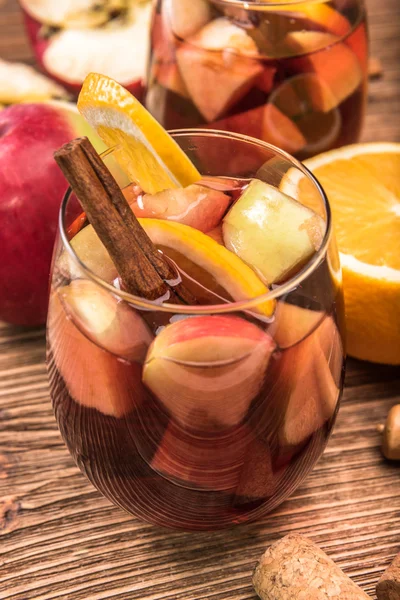 Vino tinto casero sangría con manzanas y naranjas sobre una mesa de madera . — Foto de Stock