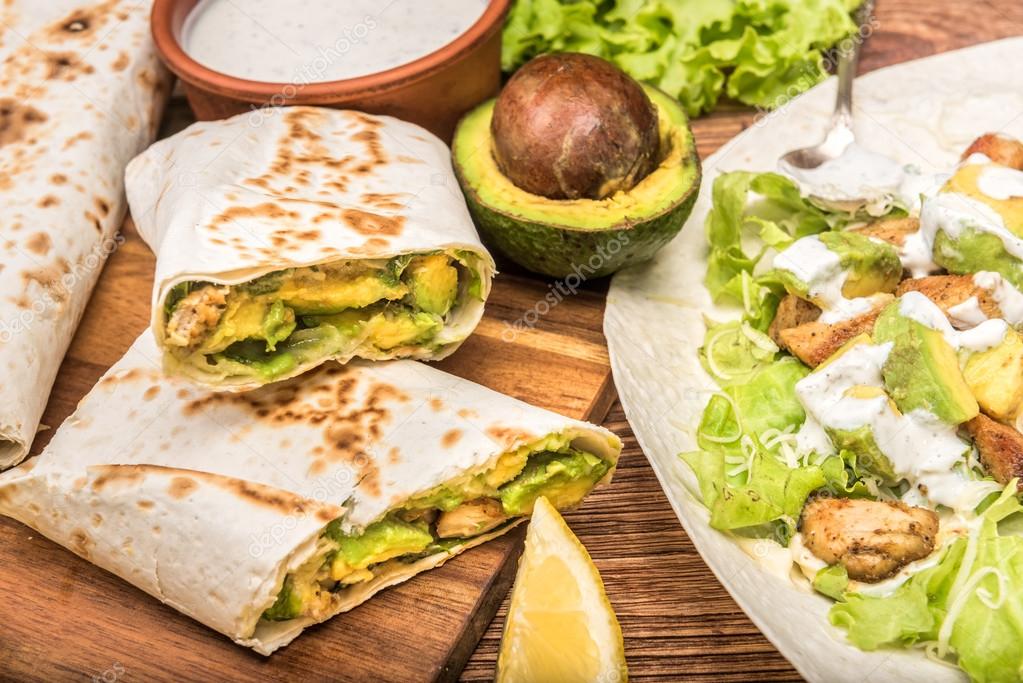 Burrito de pollo, aguacate y verduras sobre fondo de madera . fotografía de stock © RasulovS