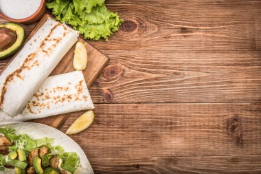 Ahşap arka plan üzerinde tavuk, avokado ve sebze börek.