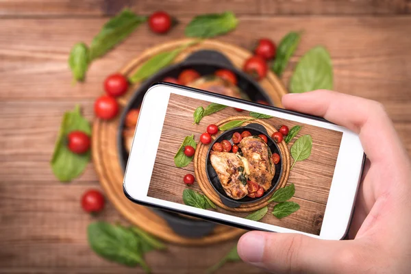 Hände fotografieren Hühnerbrust gefüllt mit Spinat und Käse mit Smartphone. — Stockfoto