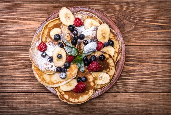 Pannenkoeken met vers fruit voor het ontbijt, bovenaanzicht. — Stockfoto