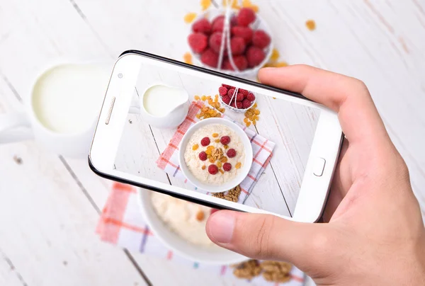 Hands taking photo oatmeal with smartphone — Stock Photo, Image