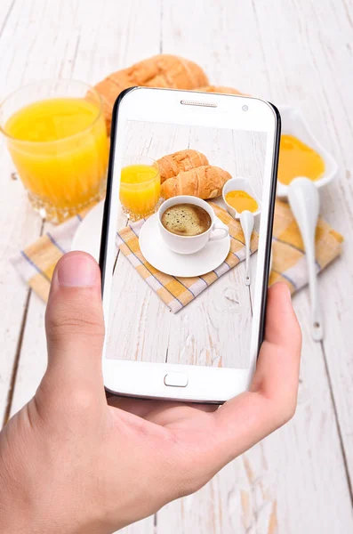 Руки фотографируют завтрак со смартфоном — стоковое фото