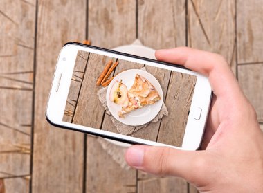 eller fotoğraf elma pasta ile smartphone alarak