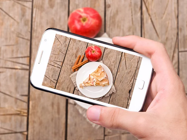 Mains prenant des photos gâteau aux pommes avec smartphone — Photo