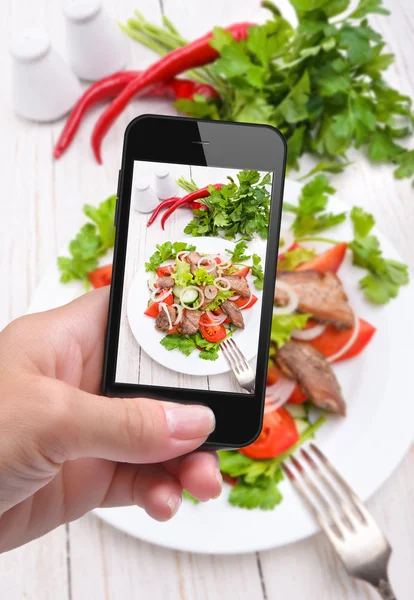 Manos tomando foto ensalada de verduras con carne con smartphone — Foto de Stock