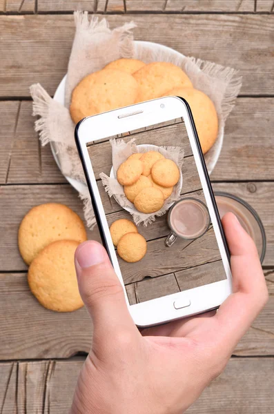 Mãos tirando foto cookie com smartphone — Fotografia de Stock