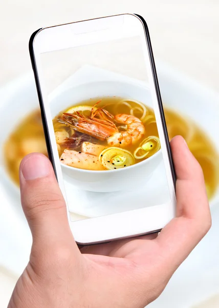 Mani che scattano foto zuppa di salmone, gamberetti con smartphone — Foto Stock