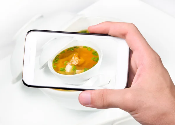 Mani che scattano foto zuppa con funghi e gamberetti con smartphone — Foto Stock