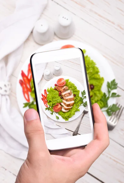 Mani che scattano foto petto di pollo con smartphone . — Foto Stock