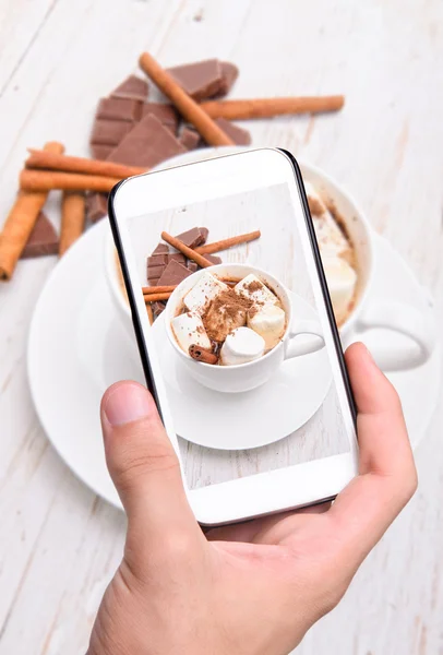 Mãos tirando fotos de cacau quente com smartphone . — Fotografia de Stock