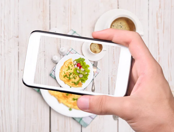 Manos tomando tortilla de huevo foto con teléfono inteligente —  Fotos de Stock