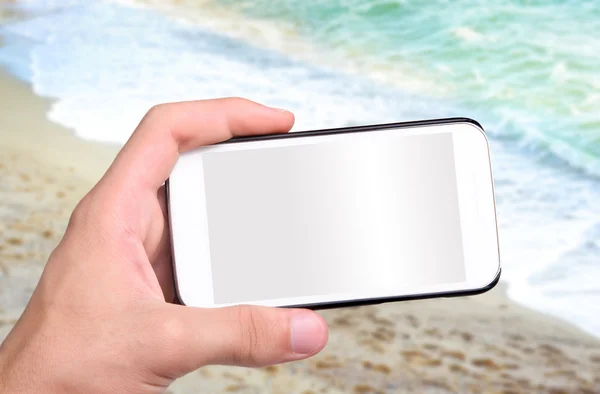 Handen nemen foto beach met smartphone. — Stockfoto