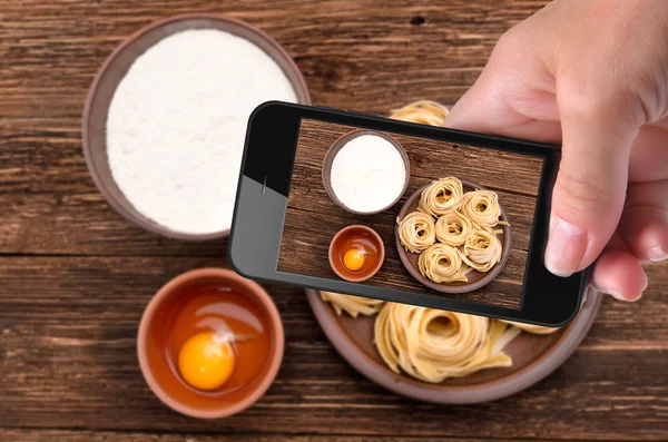 Mani che scattano foto pasta con smartphone . — Foto Stock