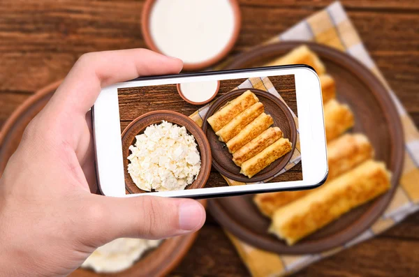 Hands taking photo pancakes with cottage cheese with smartphone. — Stock Photo, Image