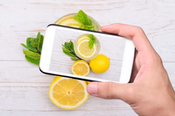 Hands taking photo lemon drink with smartphone. — Stock Photo, Image