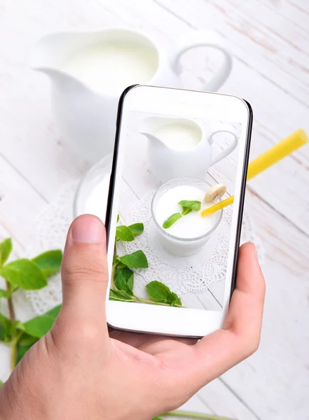 Händer tar foto milkshake med smartphone. — Stockfoto