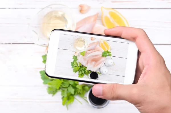 Manos tomando fotos de calamares crudos con teléfono inteligente . —  Fotos de Stock