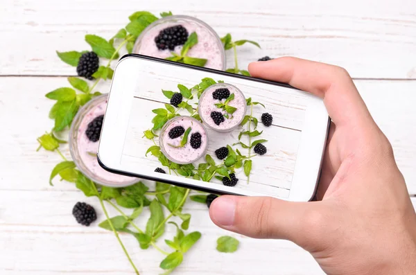 Hands taking photo blackberry smoothie  with smartphone. — Stock Photo, Image