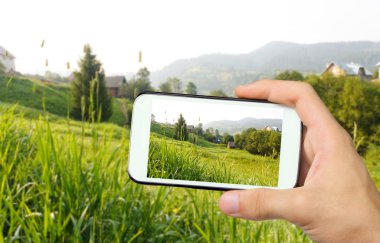 Fotoğrafta güzel bir yürüyüş yolu ile smartphone dağda eller.