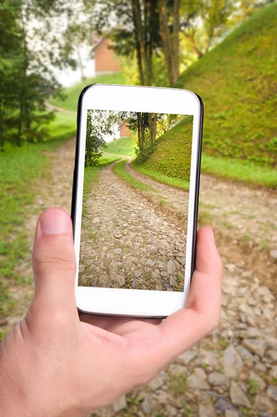 Manos tomando fotos de un hermoso sendero de trekking en la montaña con smartphone . — Foto de Stock