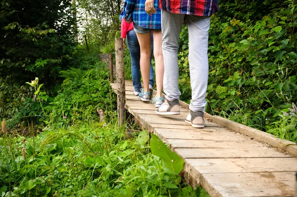 Turistas caminhando em uma ponte de madeira. — Fotografia de Stock