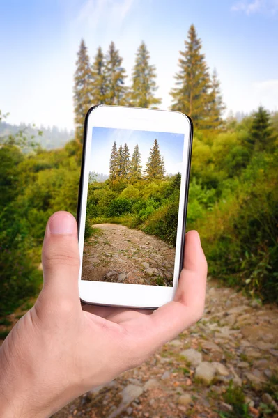 Mani che fotografano un bellissimo percorso di trekking in montagna con smartphone . — Foto Stock