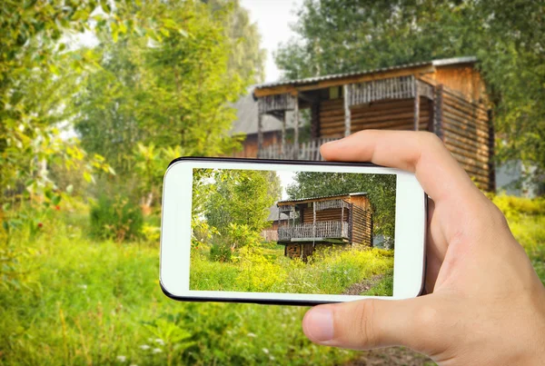 Hands taking photo mountain chalet with smartphone. — Stock Photo, Image