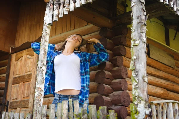 Mulher atraente na casa de madeira, ambiente de verão relaxado — Fotografia de Stock